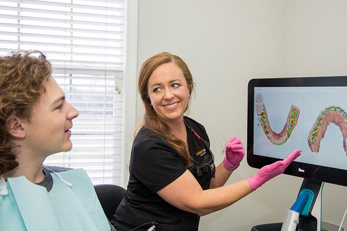 a staff happily discusses photos with patient at Legacy Hill Dentistry in Smyrna, TN